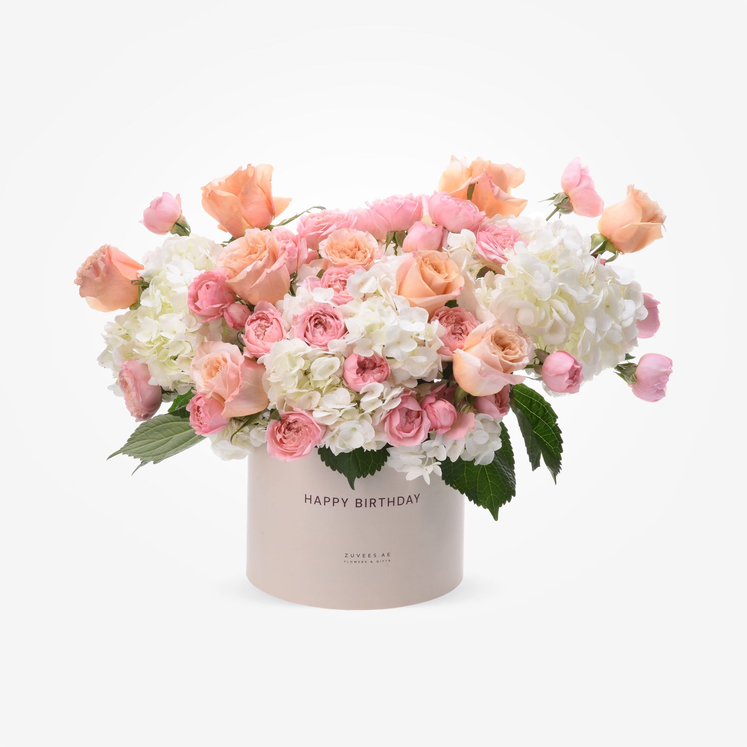 Pastel pink roses and white hydrangeas bloom in a "Happy Birthday" cylinder box.
