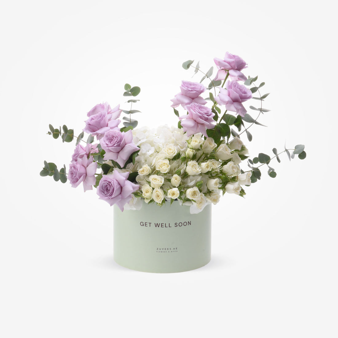 Pastel lavender roses and white blooms in mint-green "Get Well Soon" box.