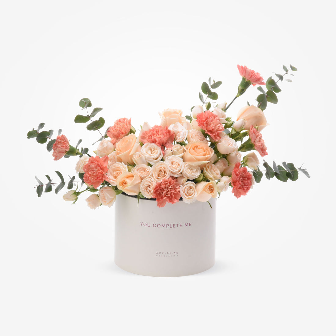 Soft peach roses and carnations in white box with "You Complete Me" text.