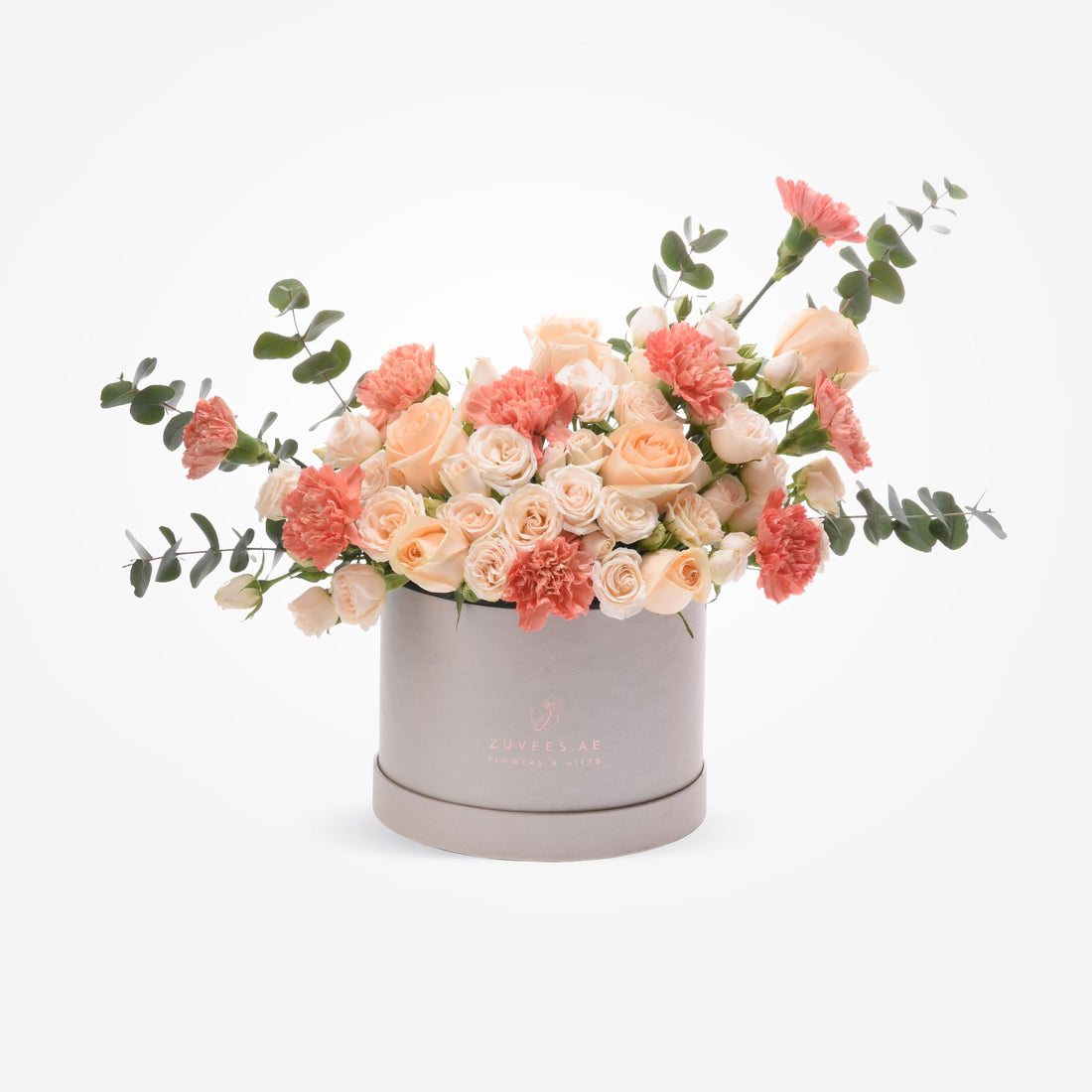 Pastel peach roses and carnations in sleek silver box with eucalyptus.