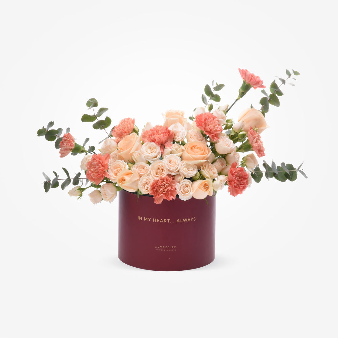Elegant peach roses and coral carnations in deep burgundy "In My Heart... Always" box.
