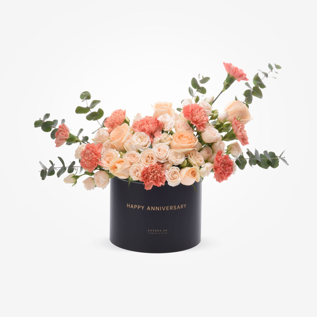 Elegant peach roses and carnations in black box with gold "Happy Anniversary" text.