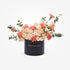 Elegant peach roses and carnations in black box with gold "Happy Anniversary" text.