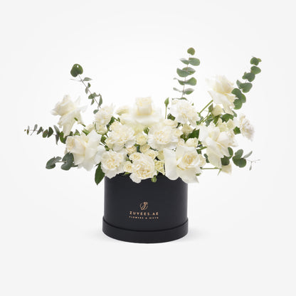 Elegant white roses and carnations with eucalyptus in a black Zuvees.AE gift box.